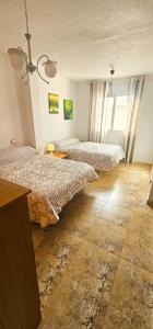 a hotel room with two beds and a table at Marolesja in Puerto de Mazarrón