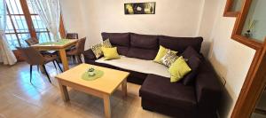 a living room with a brown couch and a table at Marolesja in Puerto de Mazarrón