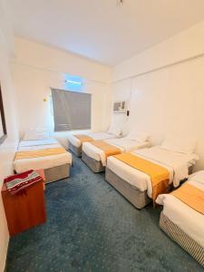 a hotel room with four beds and a window at Nour Taba Apartments in Medina