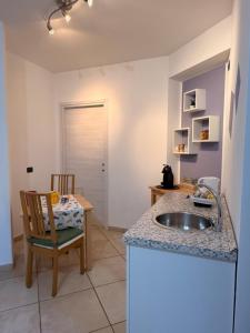 a kitchen with a sink and a table with a chair at B&B London 2010 in Vizzola Ticino