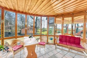 a conservatory with a table and chairs and windows at Haus Habbinga in Ovelgönne