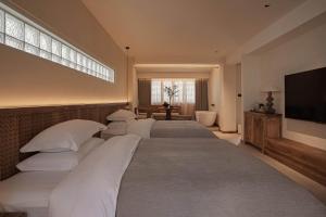 a bedroom with four beds and a flat screen tv at Dali Jiwu Hotel in Dali