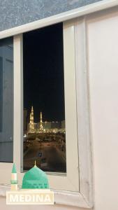 a window with a view of a city at night at Nour Taba Apartments in Medina