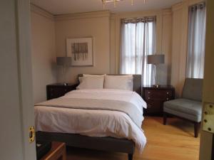 a bedroom with a large bed and a chair at Washington Park Inn in Albany