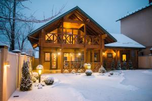 a log cabin in the snow with lights at Galant Hotel in Truskavets