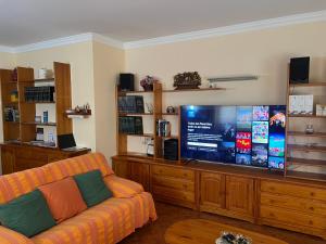 a living room with a couch and a large screen tv at Casa Alfredo in Badarán