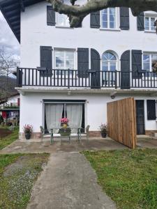 a white house with a table and chairs in front of it at Zalicarté in Saint-Jean-Pied-de-Port
