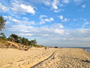 ヘルにあるSłoneczny Helの砂浜を歩く人々