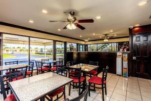 Budget Host Inn Florida City في مدينة فلوريدا: مطعم بطاولات وكراسي ومروحة سقف