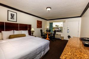 a bedroom with a bed and a desk at Budget Host Inn Florida City in Florida City