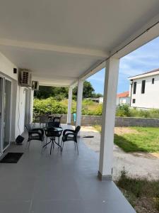 a patio with chairs and tables on a house at Dinos Apartments in Ulcinj