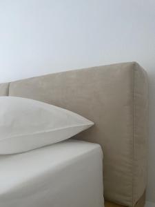 a stack of white pillows sitting on a bed at Pnoe Home in Kavála