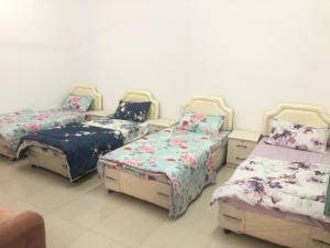 a room with four beds and a couch at Masirah oyster in Ḩilf