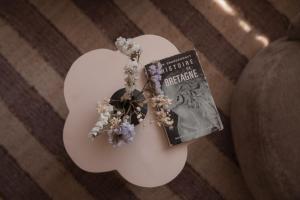 a white table with a book and flowers on it at Apparts Rennes BnB Duhamel in Rennes
