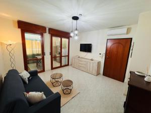 a living room with a blue couch and a tv at White House Quartu in Quartu SantʼElena