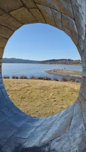 a view of the water through a circular window at Nad Hrází I in Lipno nad Vltavou +3 photos
