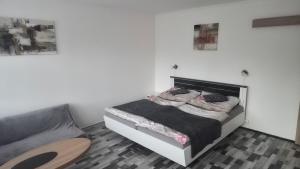 a white bedroom with a bed and a couch at Nad Hrází I in Lipno nad Vltavou