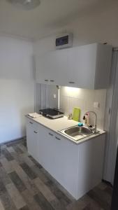 a white kitchen with a sink and a stove at Nad Hrází I in Lipno nad Vltavou