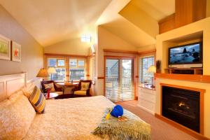 a bedroom with a bed with a fireplace and a tv at The Ocean Lodge in Cannon Beach