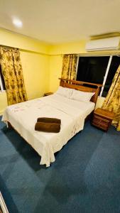 a bedroom with a large white bed in a room at A1 Apartments in Suva