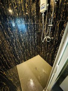 a bathroom with a shower with gold glitter at A1 Apartments in Suva