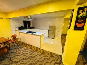 a kitchen with yellow walls and a white counter top at A1 Apartments in Suva +9 photos