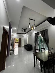 a living room with a table and a couch at Homestay kampung moden in Pendang