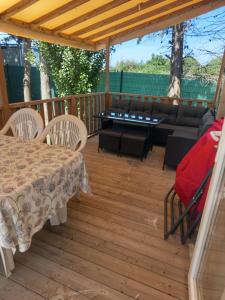 a patio with a table and chairs and a couch at mobil-home FONTAINE Jeremie in Canet-en-Roussillon
