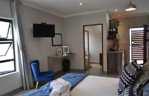 a bedroom with a bed and a chair and a television at Sleep84 in Dullstroom