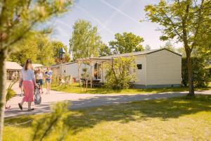 a group of people walking down a sidewalk at Zomerhuisje Chalet in Voorthuizen