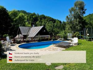 a swimming pool in front of a house at Penzion Muštelka in Rokytnice nad Jizerou