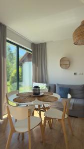 a living room with a table and chairs at Liwia Park Green House in Niechorze
