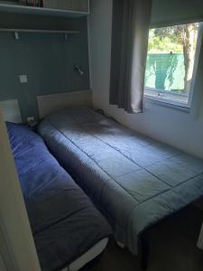 two beds in a room with a window at mobil-home FONTAINE Jeremie in Canet-en-Roussillon