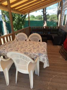 a table and chairs on a wooden deck with a table and chairs at mobil-home FONTAINE Jeremie in Canet-en-Roussillon