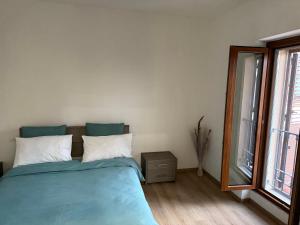 a bedroom with a blue bed and a window at Casa di Nina in Grazzano Badoglio +13 photos