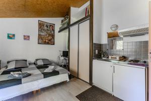 a small bedroom with a bed and a kitchen at Le Cabanon Mios in Mios