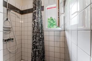 a shower with a black and white shower curtain at Le Cabanon Mios in Mios