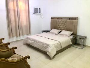 a bedroom with a large bed and a chair at Masirah oyster in Ḩilf