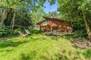 a cabin with a picnic table and chairs in the yard at La palombière in Saint-Symphorien