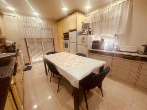 a kitchen with a white table and chairs in a kitchen at Gama Barros 22 in Charneca