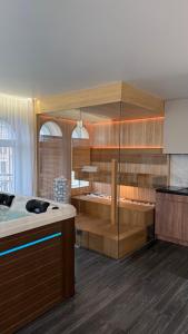 a kitchen with a tub with wooden cabinets and a counter at APETIKO APARTMENTs in Kyiv