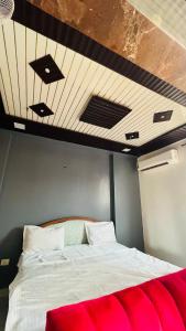 a bed in a room with a wooden ceiling at The Comfort stays gomti nagar in Lucknow +7 photos