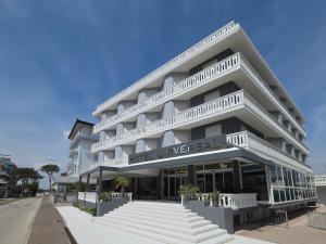 a large white building with stairs in front of it at Hotel Universal in Caorle