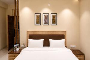 a bedroom with a large bed with three pictures on the wall at IND57 in Siliguri