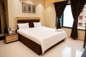 a bedroom with a large bed and a window at IND57 in Siliguri