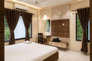 a bedroom with a bed and a desk and window at IND57 in Siliguri