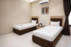 two beds in a hotel room with at IND57 in Siliguri +4 photos