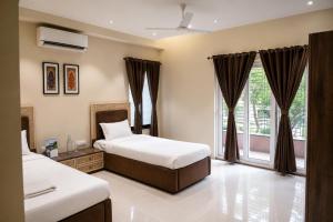 a bedroom with two beds and a window at IND57 in Siliguri
