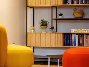 a room with a book shelf with books and plants at Adagio Nice Centre in Nice