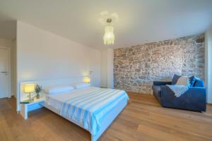 a bedroom with a bed and a blue couch at Villa Majestic with heated pool and rooftop terrace in Bol +32 photos